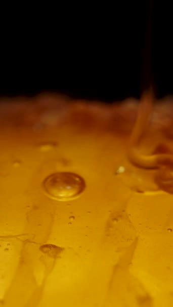 Вертикальное Видео Мед Выливают Золотые Соты Черном Фоне Долли Макро — стоковое видео