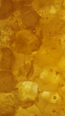 Dikey video. Balmumu bal peteklerinin üzerine bal dökülüyor. Yavaş çekim makro çekim.