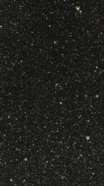 Dikey video. Cam masa bir bal katmanıyla kaplıdır ve tahta bir kaşık üzerinden kayar. Yakın plan..