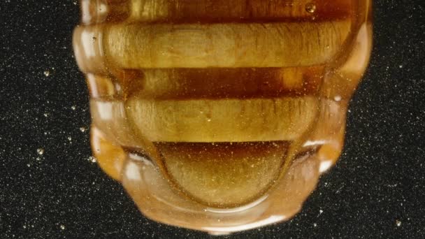 从下面的玻璃杯里看到桌子上有一个木制勺子 上面滴着蜂蜜 后续行动 — 图库视频影像
