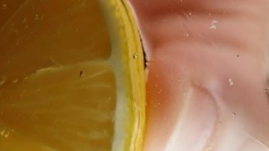 Aşağıdan şeffaf camın içinden bakıyorum, bir limon dilimini alıyorum ve yukarıdan bal tabakasına damlatıyorum, limon suyu eritiyor, camda çizgiler oluşturuyor. Makro. Kimyasal reaksiyon konsepti.