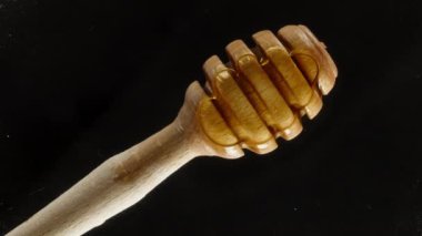 Ben bal katmanından özel bir kaşık alırken yukarıdan şeffaf bir camın arkasından bakın. Siyah bir arkaplana yakın çekim.