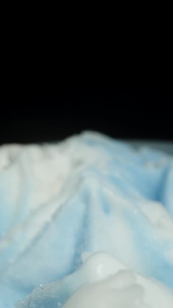 垂直录像 蓝白相间的雪片状冰淇淋 背景是黑色的 多利滑翔机极端特写 — 图库视频影像