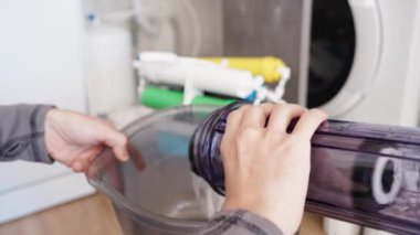 Eski ve kirli su filtresi yuvadan çıkartılır ve kameraya gösterilir.