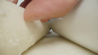 Bir adam arındırma için kullanılmış bir su tabakası filtresini inceler, katmanları kesilir ve elleri beyaz kalıntılarla kaplıdır. Dolly kaydırıcı aşırı yakın çekim.