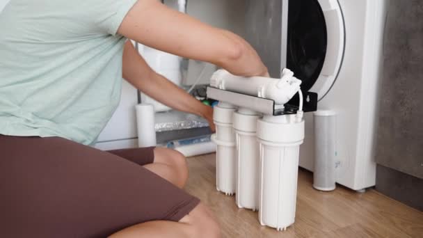 一位年轻妇女正在自己更换厨房的水过滤器 以便安装反渗透系统 — 图库视频影像
