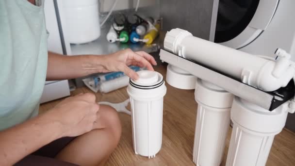 Uma Jovem Está Sentada Chão Cozinha Substituindo Filtros Água Sistema — Vídeo de Stock
