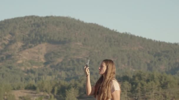 Een Jonge Vrouw Met Lang Haar Vangt Prachtige Bergen Met — Stockvideo