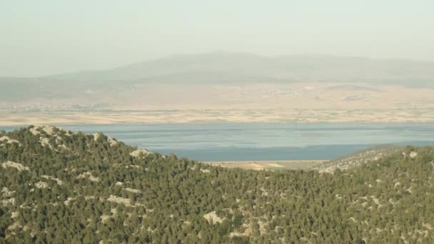 在高山上乘着汽车旅行 可以看到高山后面的一个巨大的湖泊 — 图库视频影像