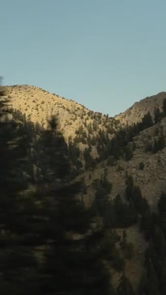 垂直录像 从被落日的最后一缕光芒照亮的高山山峰的移动的汽车上看到的风景 — 图库视频影像
