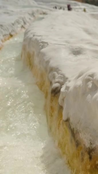バーティカルビデオ パムカレの白いトラバーチンの頂上に 水はゆっくりと動くカルカイトの足跡を通って流れます — ストック動画