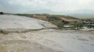 Beyaz dağın tepesinde yürüyorum, Pamukkale 'de Travertines, ve tepeden bir panorama alıyorum..