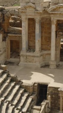 Dikey video. Roma Sütunları ve Taş Heykelleri, Panorama Antik Amfitiyatrosu.