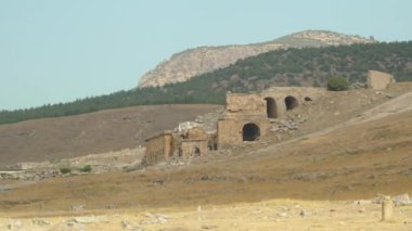 Antik kalıntılar, dağın eteğindeki taş evlerin kalıntıları. Panorama.