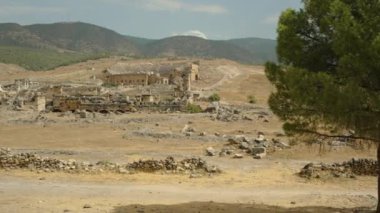 Dağların eteklerindeki antik şehir kalıntıları, her yerde kuru otlar ve dağınık taşlar..