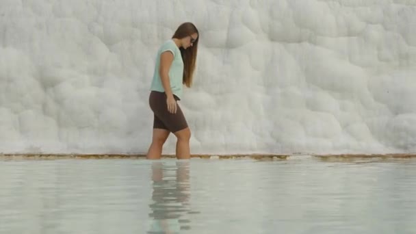 Mulher Caminha Cuidadosamente Sobre Água Segura Uma Rocha Branca Antigos — Vídeo de Stock