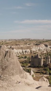Dikey video. Aşk Vadisi denen eski ve kutsal bir yerin panoraması ve Peri Bacaları olarak bilinen uzun taşlar..
