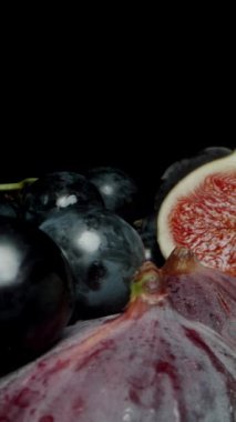 Dikey video. Kamera İncir, Siyah ve Yeşil Üzümlerle Masada İlerliyor. Teker teker alıp yiyorum. Dolly kaydırıcı aşırı yakın çekim.