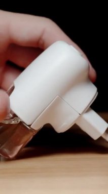 Dikey video. Elektrik Aygıtı Sıvı Sivrisinek Kovucu ile İnceleniyor.