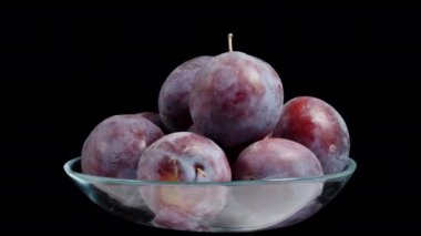 Cam bir kasede erikler. Siyah bir arkaplanda dönerler, döngülü video, izole edilmiş..