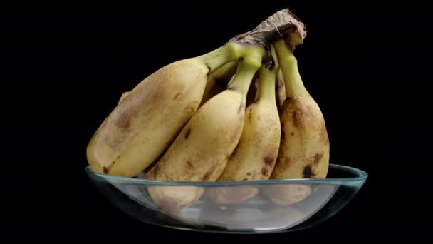 Zralé Banány Skleněné Misce Otočí Černém Pozadí Smyčka Videa Izolované — Stock video