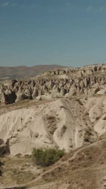 Dikey video. Türkiye 'deki Hayal gücü Vadisi' ndeki kayaların ve dağların yukarıdan aşağıya birinci şahıs görüntüsü, açık hava.