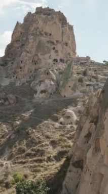 Dikey video. Türkiye 'de antik bir kentin yüksek uçurumlarında, panoramasında antik insanların ikamet etmeleri.
