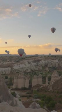 Dikey video. Türkiye 'nin başkenti Kapadokya' da şafak vakti kanyonlarda ve Aşk Vadisi 'nde eş zamanlı olarak çok sayıda sıcak hava balonu havalandı..