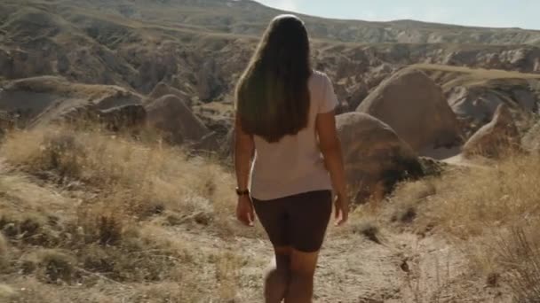 Молодая Женщина Путешествует Бесплодной Долине Древними Большими Камнями Палящим Солнцем — стоковое видео