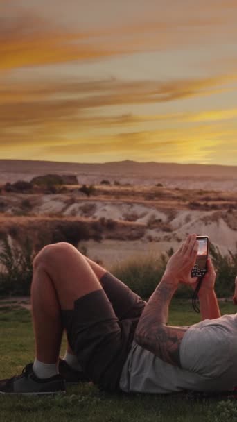 Vertical Video Young Man Woman Admire Sunset While Lying Meadow — Stock Video