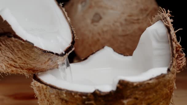 Zwei Hälften Einer Gebrochenen Kokosnuss Und Saft Fließt Zeitlupe Von — Stockvideo