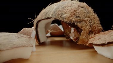 Masaya serpilmiş kırık hindistan cevizi parçaları, kamera aralarından geçer. Makro