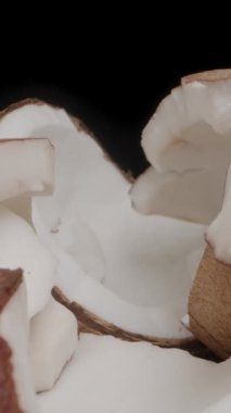 Dikey video. Kamera, masaya dağılmış hindistan cevizi parçalarına yaklaşır ve onları hareket ettirir. Yakın plan, Dolly 'nin fotoğrafını çeker..