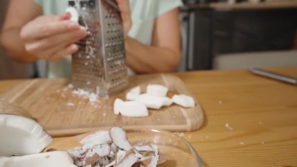 Woman Grates Coconut Pieces Zamieniając Strzępy Używając Metalowej Zapiekanki Zbliżenie — Wideo stockowe