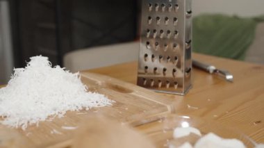 Tahta mutfak masası ve hindistan cevizi rendelenmiş metal rendesi. Kaydırıcı Vuruşu.