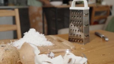 Mutfak Masası Coconut ve Ezilmiş Beyaz Et ile kaplı, Arka planda Bir Kadın Mutfak İçlerinde. Doli Vuruşu.