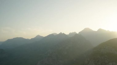 Batan Güneşin Son Işınları deniz boyunca uzanan Uzun Dağlar boyunca yayılıyor. Dağların zirvesinden bir Panorama Dağlarda bir Yolculuk.