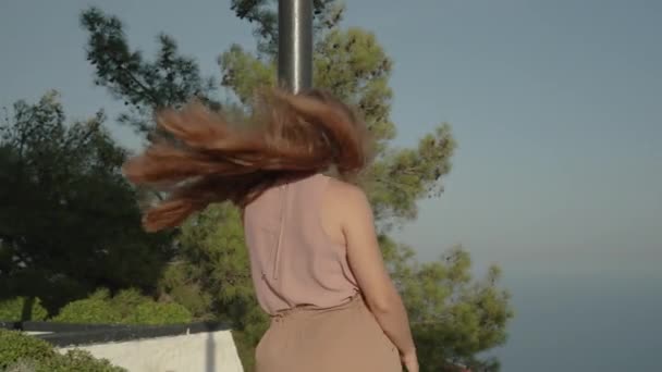 여자의 머리는 그녀가 높이에서 바다를 감상하는 바람에 강하게 — 비디오