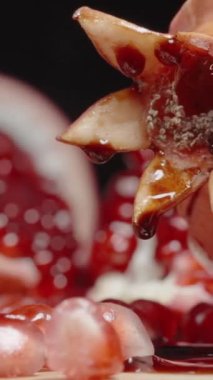 Dikey video. Nar tohumlarının üzerine nar sosu dökerim, yakın plan. Lezzeti Artırıyorum.