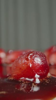 Dikey video. Çeşitli Bulaşıklar İçin Nar Sos Damlaları Nar Tohumları 'na damlıyor, Masa' ya yayılıyor. Yavaş çekim. Makro.