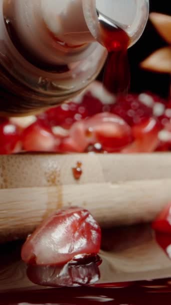 垂直录像 石榴汁从酒壶中滴下 并配上调酒器 红色的果汁从桌子上打散滴 石榴籽就在附近 多利滑翔机极端特写 — 图库视频影像