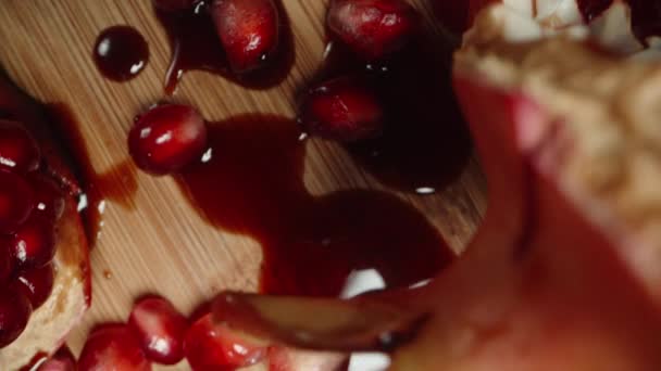 ポメグラネートの種子と赤いジュースがテーブルにこぼれました トップダウンビュー ドリースライダー極端なクローズアップ — ストック動画
