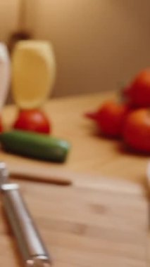 Dikey video. Tahta Masa 'da, bir Burger için İçindekiler Açılmıştır. Sıcak, sinematik bir iç mekanda, lambaların yumuşak parıltısıyla aydınlatılmış bir ev yemeği..