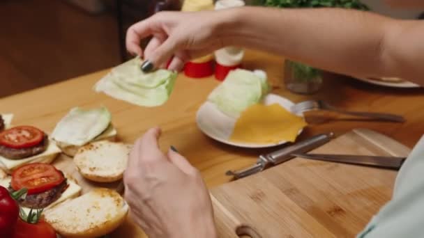 一个女人把莴苣叶子放在烤肉上的番茄顶部 舒适的氛围及自制食物 — 图库视频影像