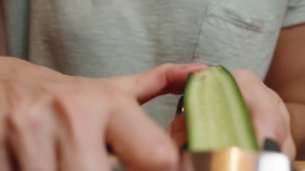 一个女人用一把特殊的菜刀 把新鲜的黄瓜切成薄片 做成汉堡 — 图库视频影像