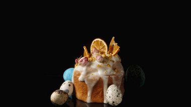 Kurumuş Portakal Dilimleri ve Gül Çiçekleri ile süslenmiş, Siyah Arkaplanda Yumurtalı Paskalya Keki.