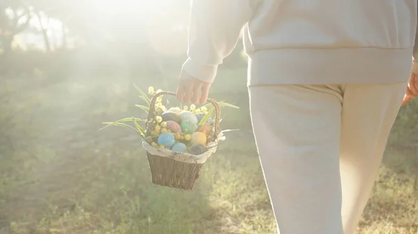 Sunbeams Through the Trees, and a Woman in White with a Basket of Easter Eggs Walking Towards Them, Strolling through the Forest.