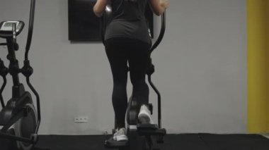 Eliptik Eğitimli Genç Kadın. Arka Manzara. Spor salonunda idman..