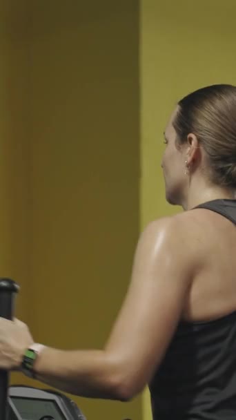 Вертикальное Видео Молодая Женщина Занимается Эллиптическим Тренером Вспотела Эффективная Тренировка — стоковое видео