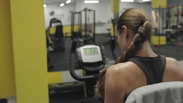 Kvinnan Gym Stationär Cykel Trampa Och Hennes Rygg Täckt Svettdroppar — Stockvideo